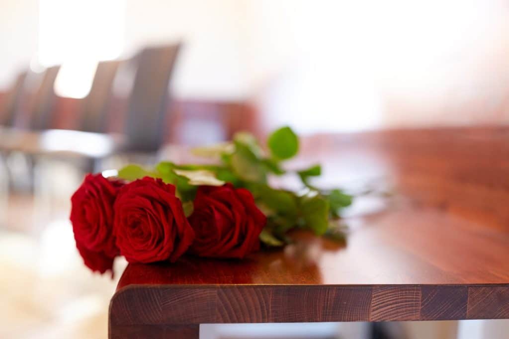 red roses on bench at funeral in church